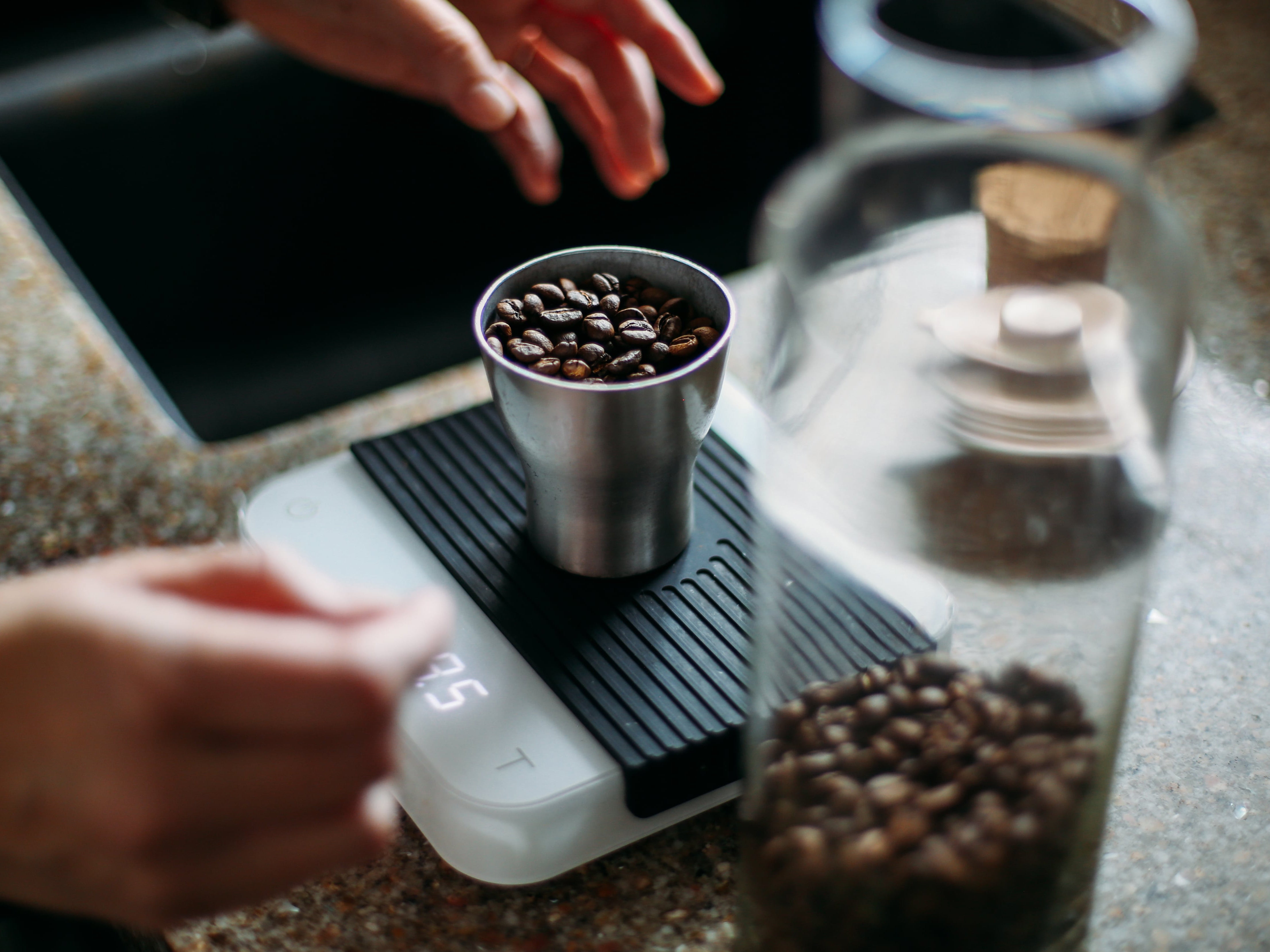 Michael is weighing the whole beans on a scale.